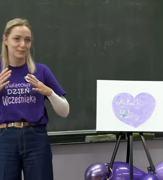 Małgorzata Słabiak w fioletowej koszulce Światowego Dnia Wcześniaka podczas prelekcji w szkole